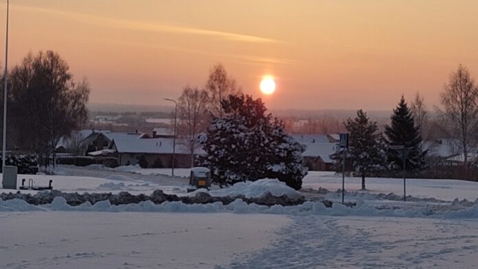 Päikesetõus talvel. Esiplaanil asula.